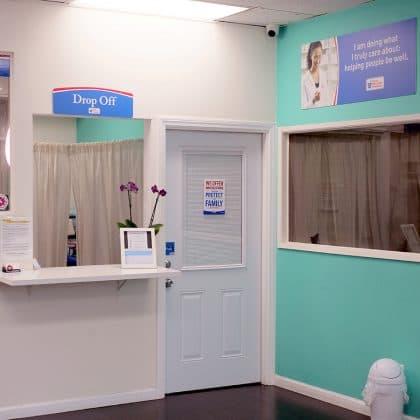 The drop-off counter inside Vine Discount Pharmacy with a clean, friendly waiting area